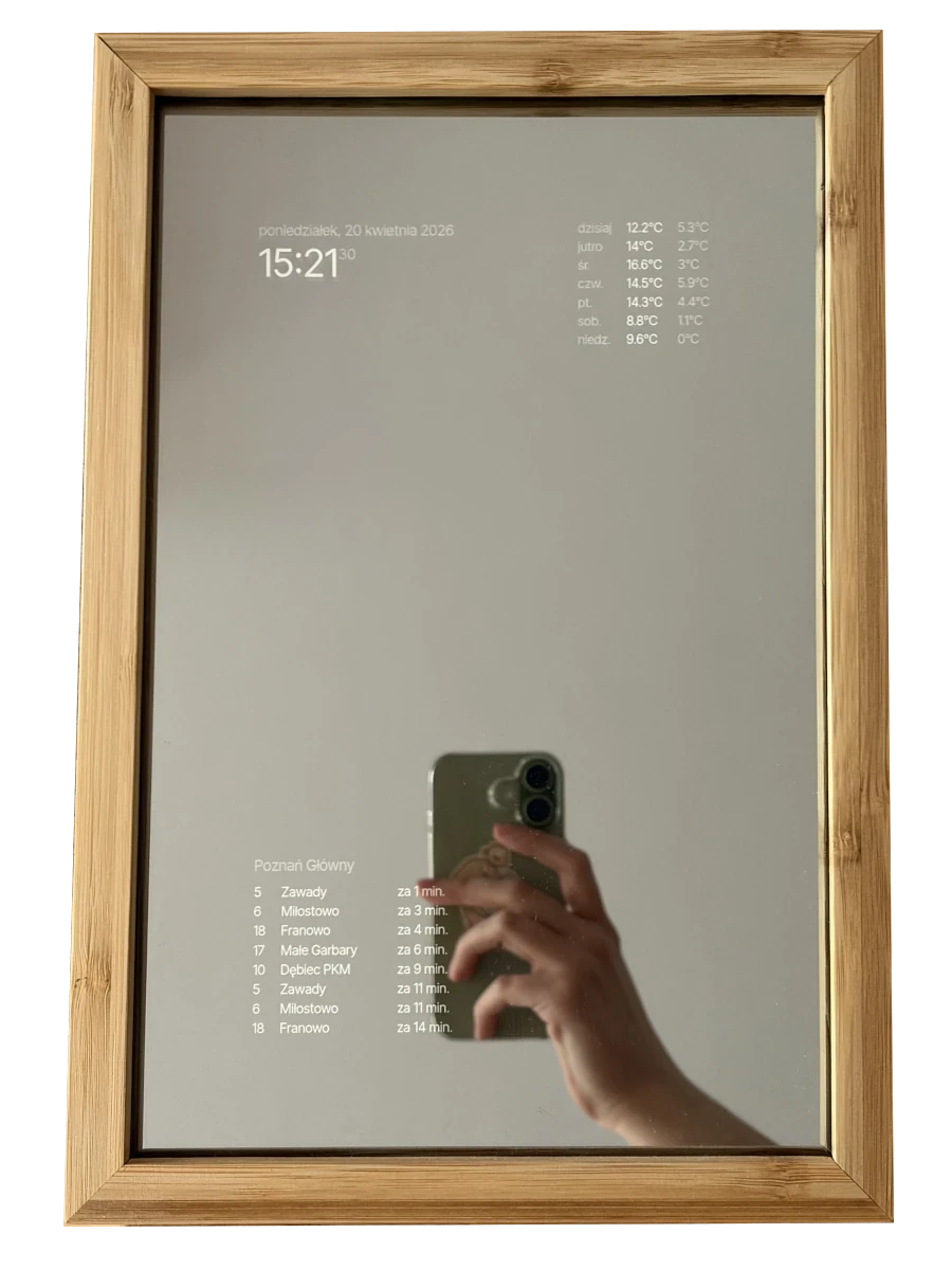 Photo of a smart mirror in a bamboo frame. It shows the time and the date, the weather for the week, and live departures from my nearest tram stop.